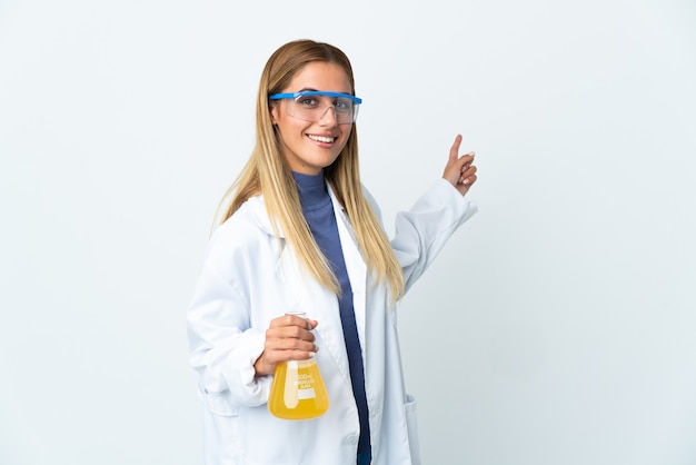 Jeune femme scientifique isolée sur un mur blanc pointant vers l'arrière