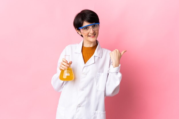 Jeune femme scientifique isolée pointant vers le côté pour présenter un produit