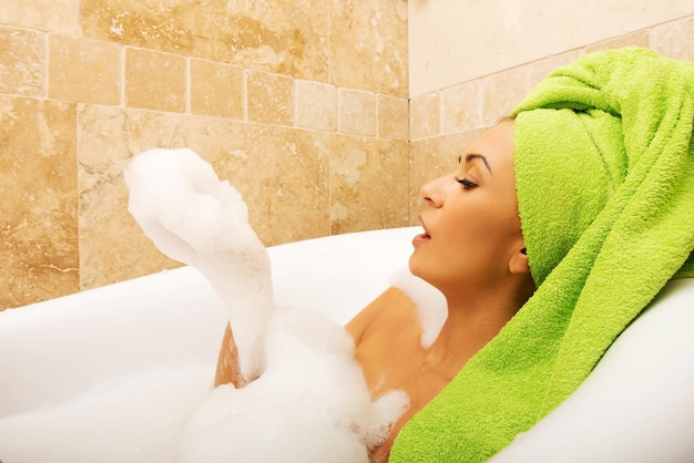 Photo une jeune femme se baigne dans une baignoire.