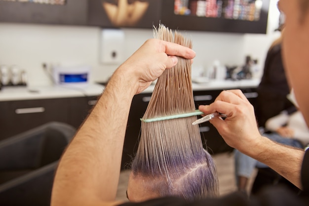 Jeune femme se coupe de cheveux dans un salon de beauté