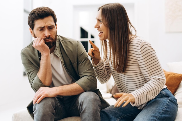 Une jeune femme se dispute avec son triste mari à la maison.