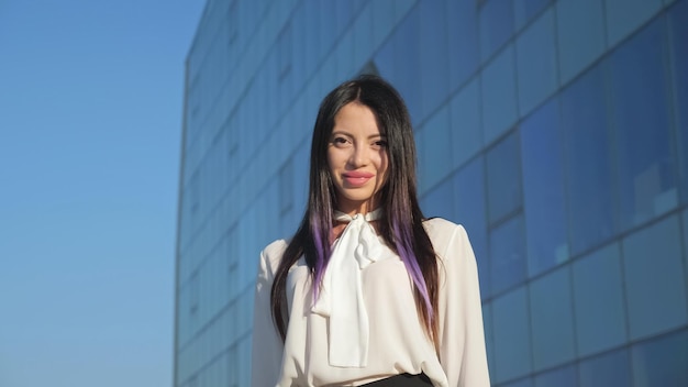 La jeune femme se dresse contre la façade en verre du centre d'affaires