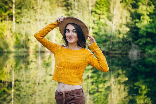 Jeune femme se dresse sur un pont sur un lac avec un paysage d'automne. Tonifiant.