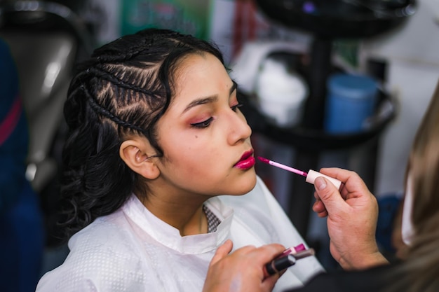 Jeune femme se maquiller et se coiffer dans un spa professionnel ou un salon de coiffure.