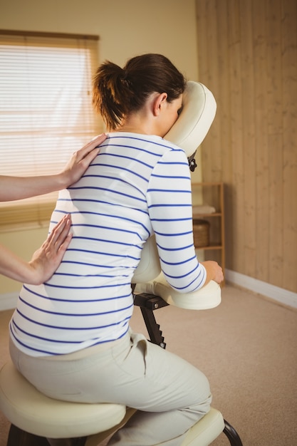 Photo jeune femme se massage dans une chaise