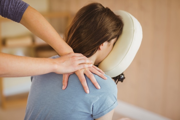 Photo jeune femme se massage dans une chaise