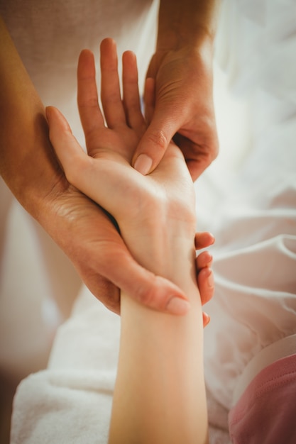 Jeune femme se massage des mains