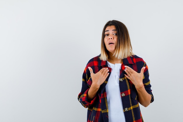 Jeune femme se montrant avec les mains sur fond blanc