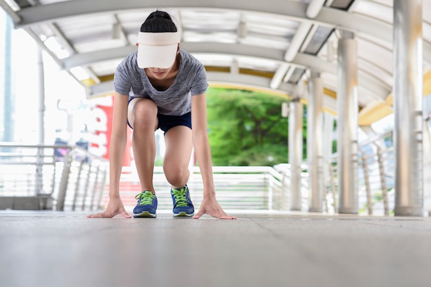 Jeune femme se préparant à courir dans la ville.