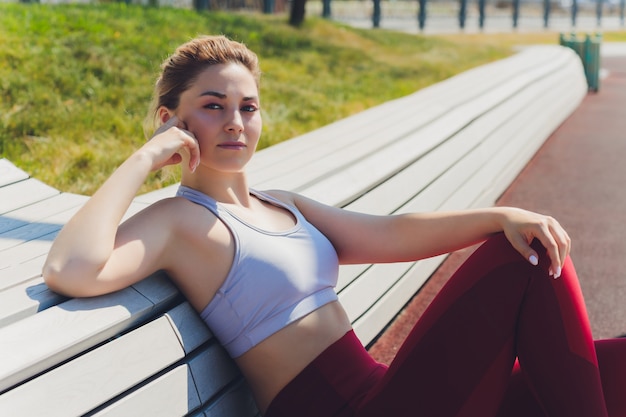 Une jeune femme se prépare aux sports de plein air sur la promenade moderne près de son complexe d'appartements.