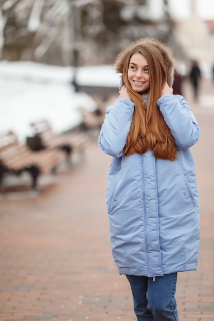 Jeune femme se promène dans le parc d'hiver.