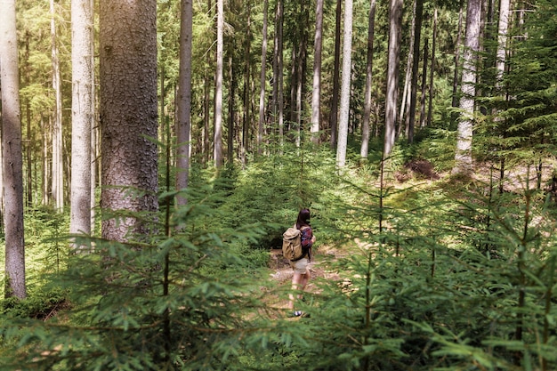 Jeune femme se promène avec un routard dans la forêt. Concept de mode de vie actif et sain