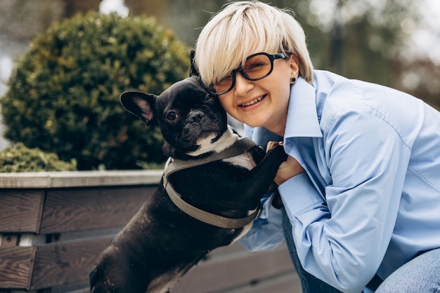 Jeune femme se promener avec son animal de compagnie bouledogue français