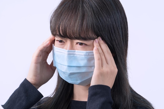 Jeune femme se sent mal à la tête étourdie malade en portant un masque médical bleu sur le fond gris gros plan copie espace