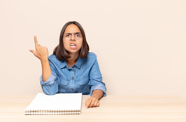 Jeune femme se sentant confuse et perplexe, montrant que vous êtes fou, fou ou hors de votre esprit