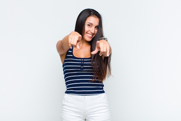 Jeune femme se sentant heureuse et confiante, pointant avec les deux mains et en riant, en vous choisissant