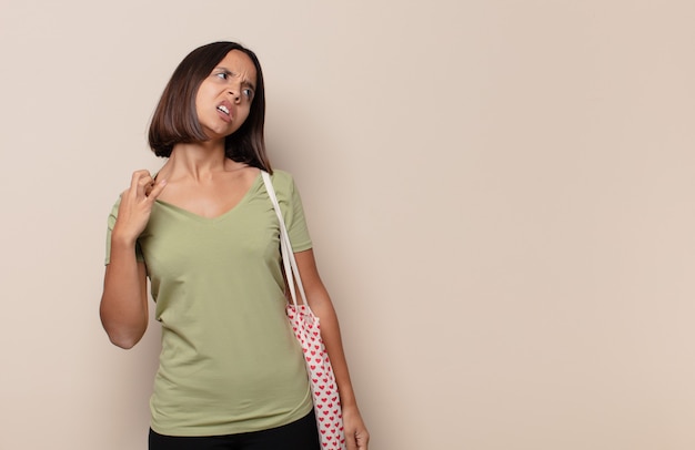 Jeune femme se sentant stressée, anxieuse, fatiguée et frustrée, tirant le cou de chemise, à la frustration de problème