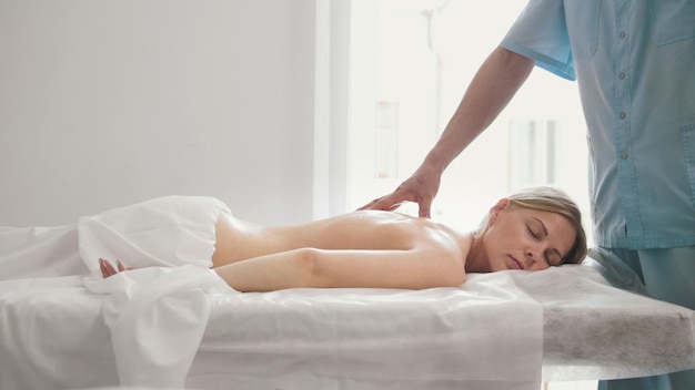 La jeune femme se trouve sur une table de massage - thérapie manuelle thérapeutique, médecine