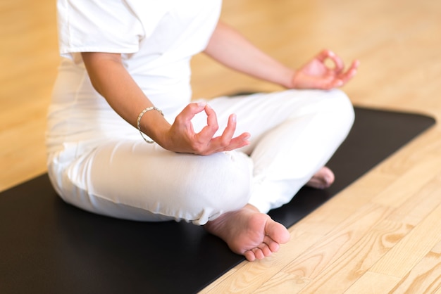 Jeune femme, séance, croix, jambes, sur, les, plancher, faire, yoga, dans, studio