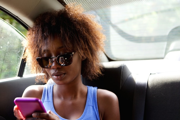 Jeune femme, séance n, banquette arrière, de, voiture, regarder, téléphone portable