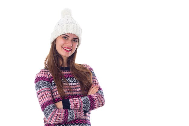 Jeune femme séduisante au chapeau blanc et pull violet sur fond blanc en studio