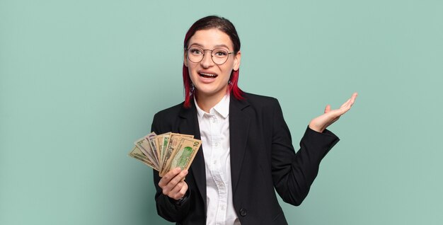 Jeune femme séduisante aux cheveux roux se sentir heureuse, excitée, surprise ou choquée, souriante et étonnée de quelque chose d'incroyable