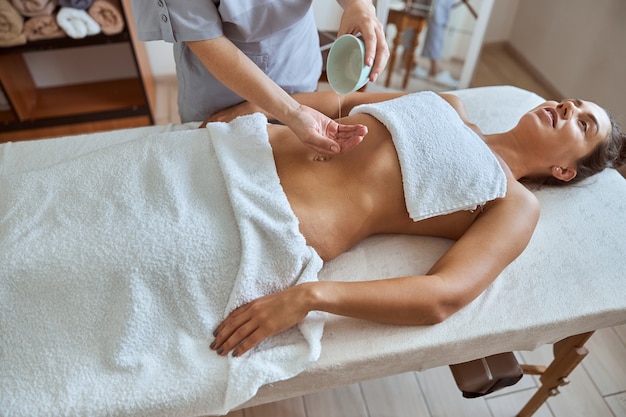 Une jeune femme séduisante dans un salon de massage a des procédures de beauté et de soins de santé