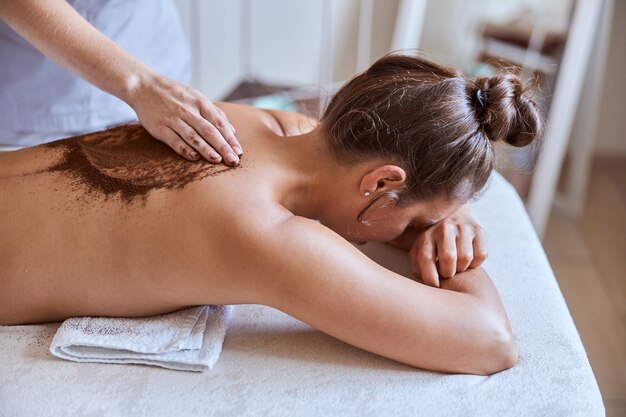 Une jeune femme séduisante dans un salon de massage a des procédures de beauté et de soins de santé