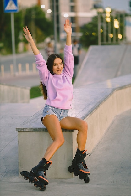 Jeune femme séduisante avec des patins à roulettes dans le parc