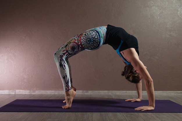Jeune femme séduisante pratiquant le yoga portant des vêtements de sport