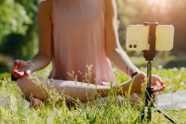 Une jeune femme séduisante pratiquant le yoga et s'étendant à l'extérieur