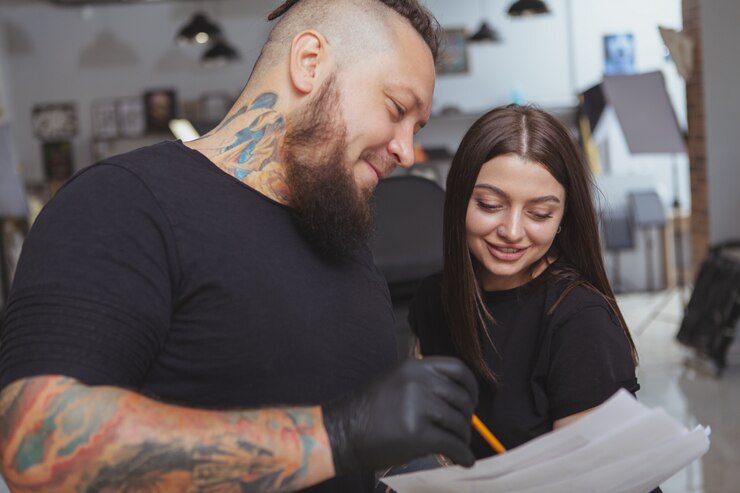 Jeune femme séduisante se faisant tatouer par un tatoueur professionnel