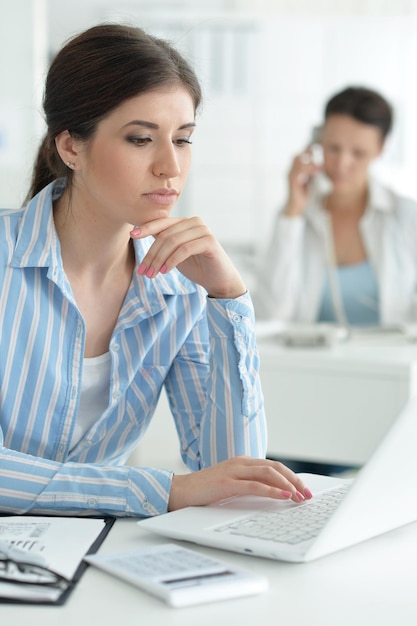 Jeune femme séduisante travaillant sur ordinateur portable