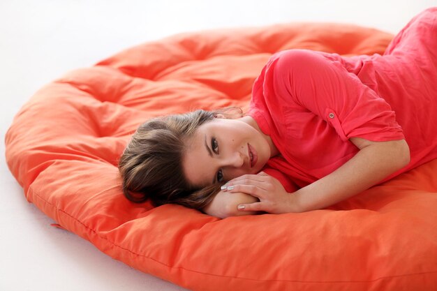 Photo une jeune femme sensuelle rêvant sur une couverture rouge