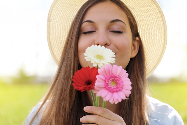 Jeune femme, sentir, gerbera, fleurs