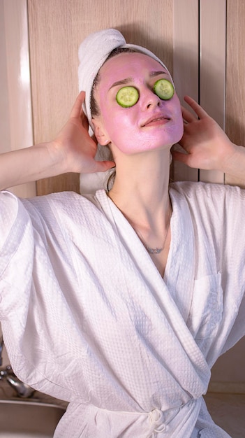 Une jeune femme sérieuse applique un gommage au café sur le visage qui pèle la peau