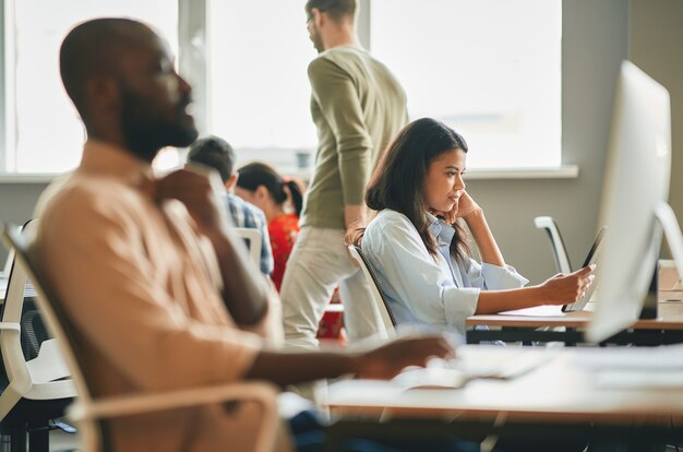 Jeune femme sérieuse étant concentrée au travail de bureau