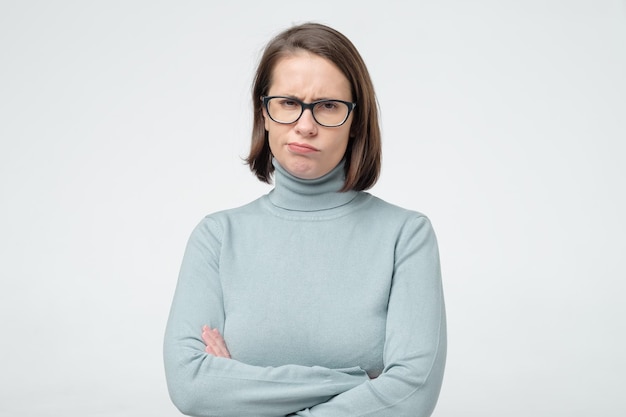 Jeune femme sérieuse avec une expression désapprobatrice sur son visage soupçonnant quelqu'un de mentir