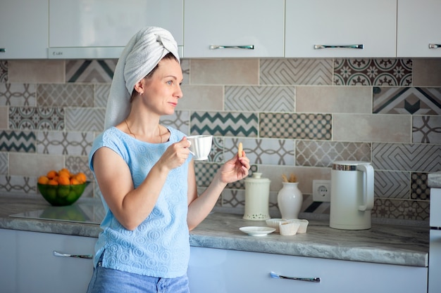 Jeune femme avec une serviette sur la tête le matin