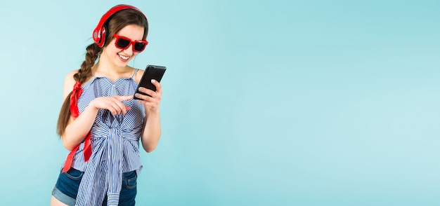 Jeune femme sexy avec un casque et un téléphone portable