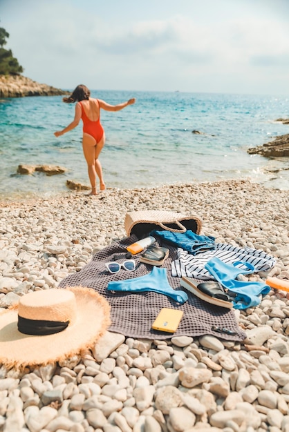 Jeune femme sexy en maillot de bain rouge en mer trucs de plage sur les vacances d'été de couverture