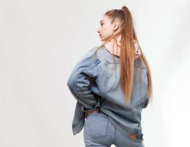 Jeune femme sexy en vêtements denim isolé sur fond blanc