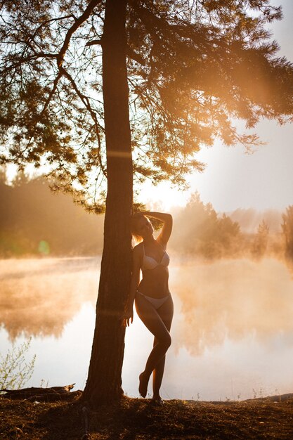 Jeune femme en silhouette au bord de la mer