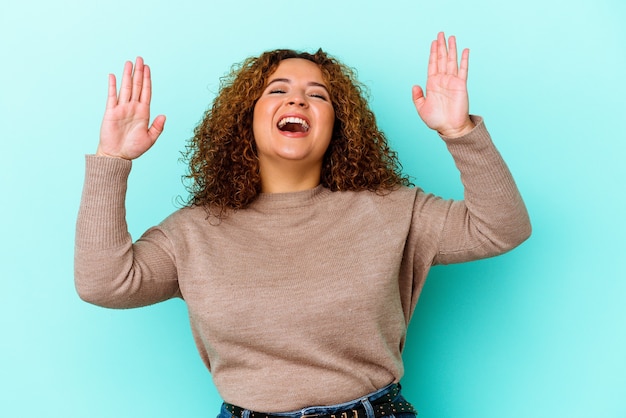 Jeune femme sinueuse latine isolée sur mur bleu joyeux rire beaucoup. Concept de bonheur.