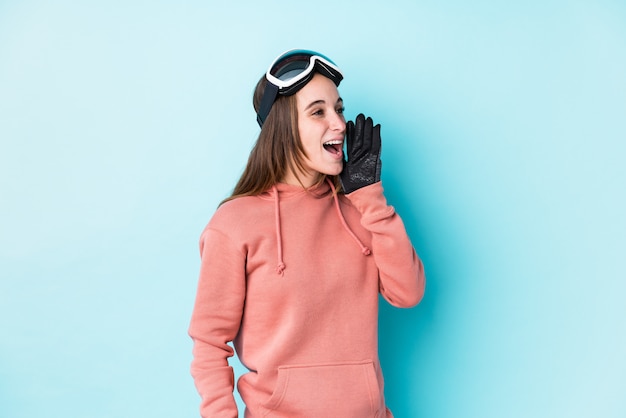 Jeune femme skieur criant et tenant la paume près de la bouche ouverte.