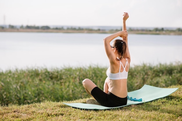 Jeune femme slim fit faisant de l'exercice de sport à l'extérieur dans le parc à la journée ensoleillée