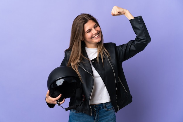 Jeune femme slovaque tenant un casque de moto isolé sur fond violet célébrant une victoire