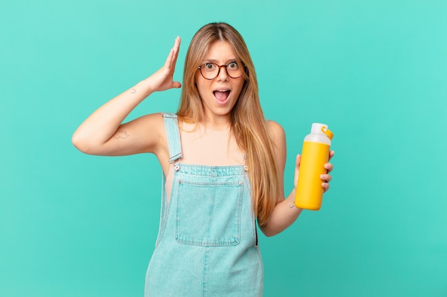 Jeune femme avec un smoothy criant avec les mains en l'air