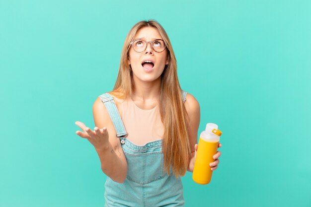 Jeune femme avec un smoothy à la désespérée, frustrée et stressée