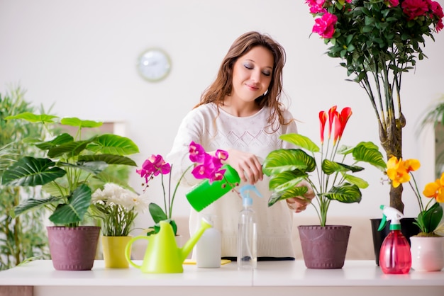 Jeune femme soignant des plantes à la maison